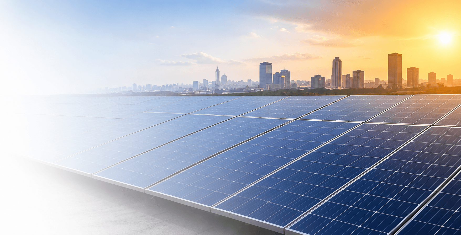 Rooftop solar panels overlooking a city skyline at sunset